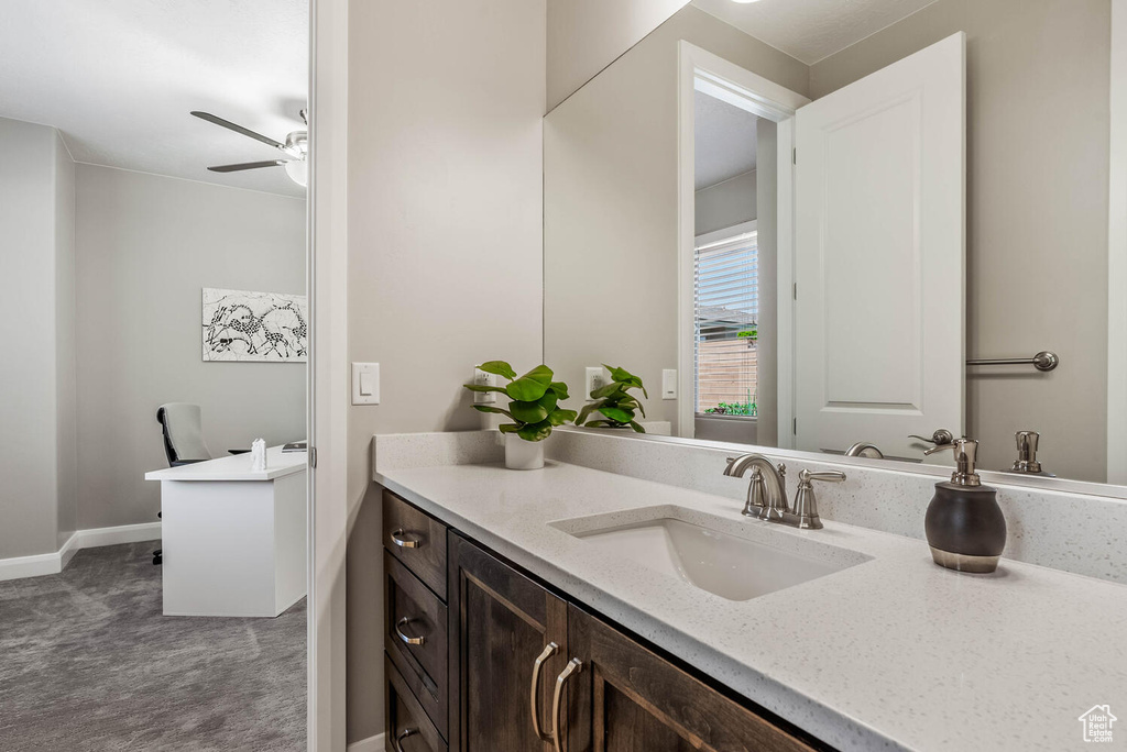 Bathroom with ceiling fan, vanity, and baseboards