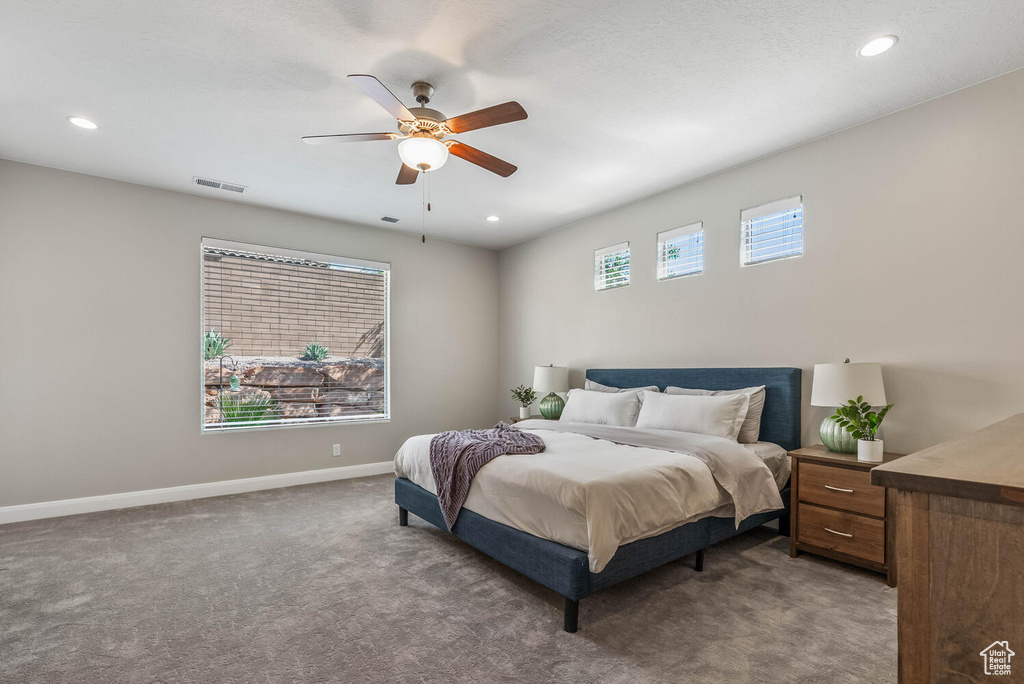 Carpeted bedroom featuring baseboards, a ceiling fan, and recessed lighting