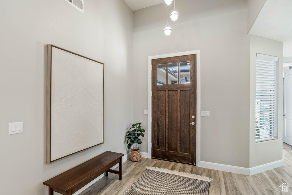 Foyer entrance with light wood-style flooring and baseboards