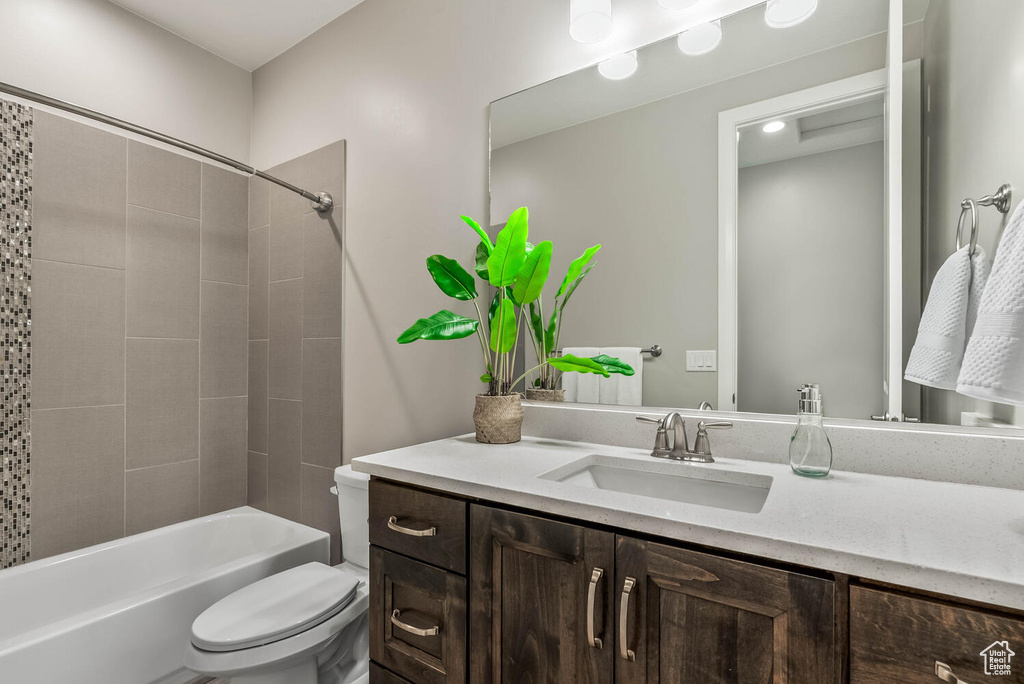 Bathroom with toilet, vanity, and shower / bath combination