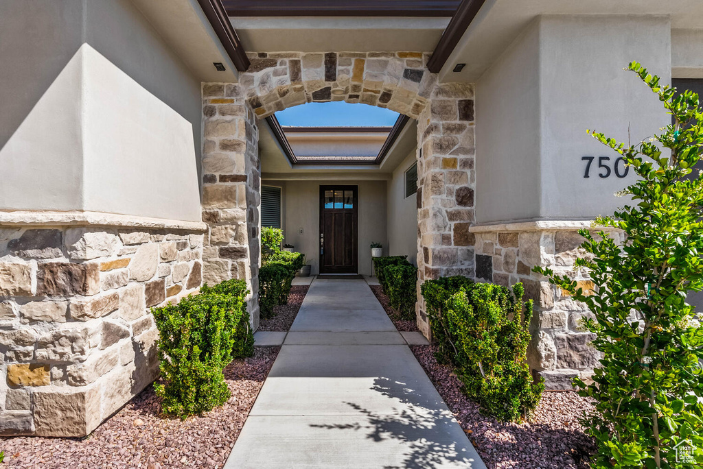 Doorway to property featuring stone siding and stucco siding