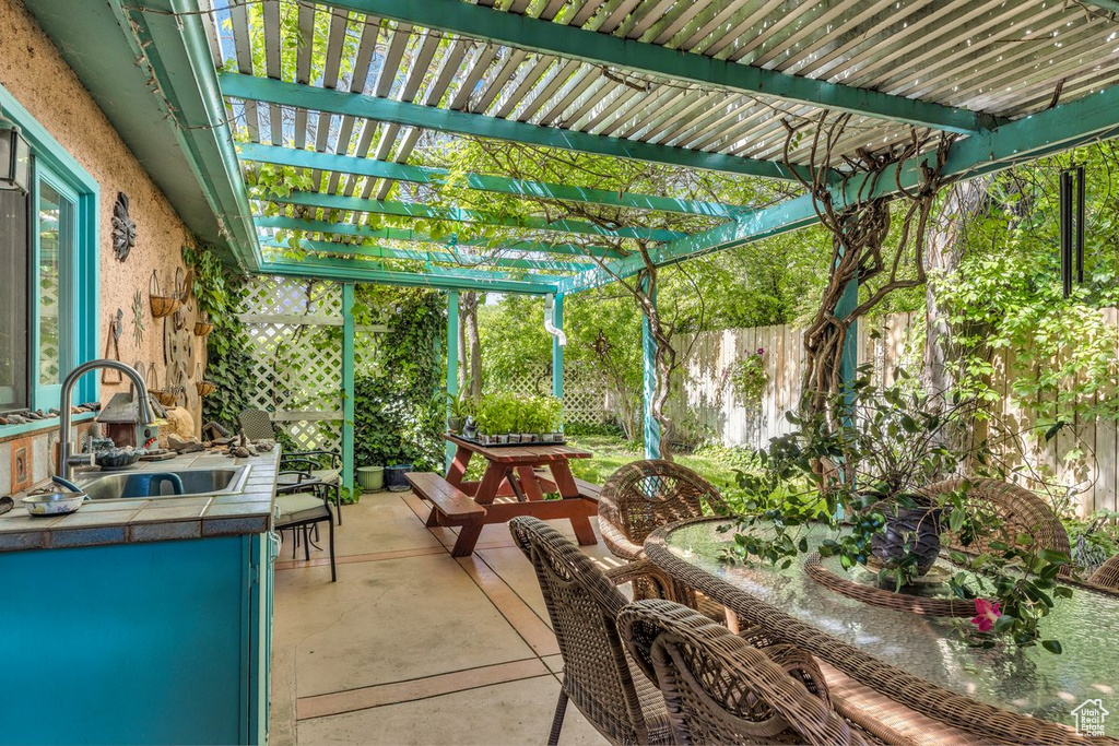 Sunroom / solarium with a sink, concrete floors, and exterior kitchen