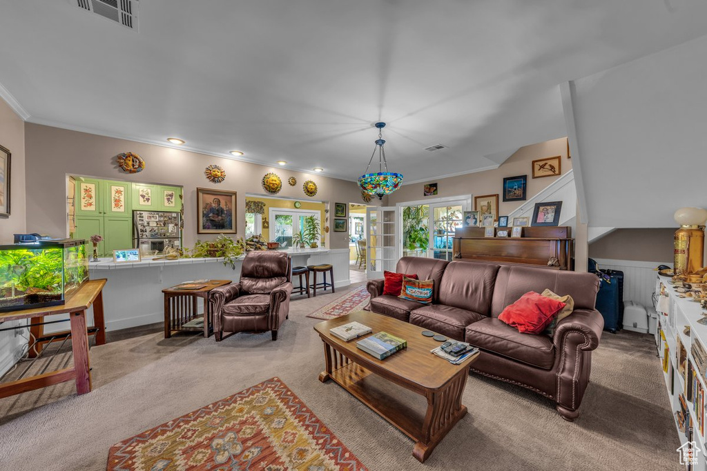 Carpeted living room with ornamental molding and recessed lighting