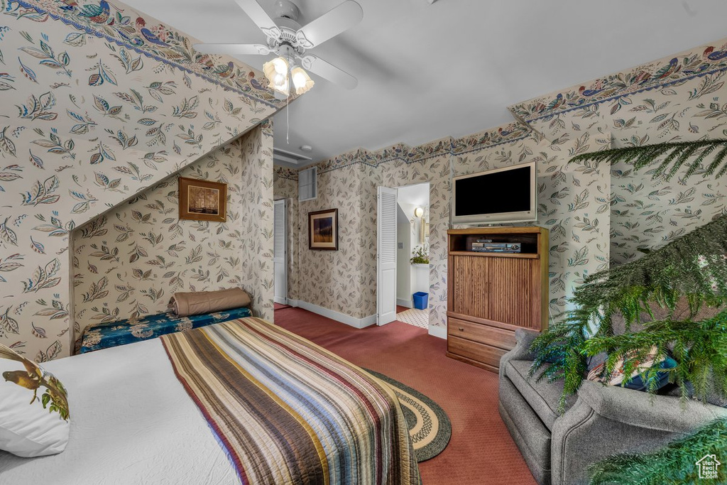 Carpeted bedroom with wallpapered walls, ceiling fan, and baseboards