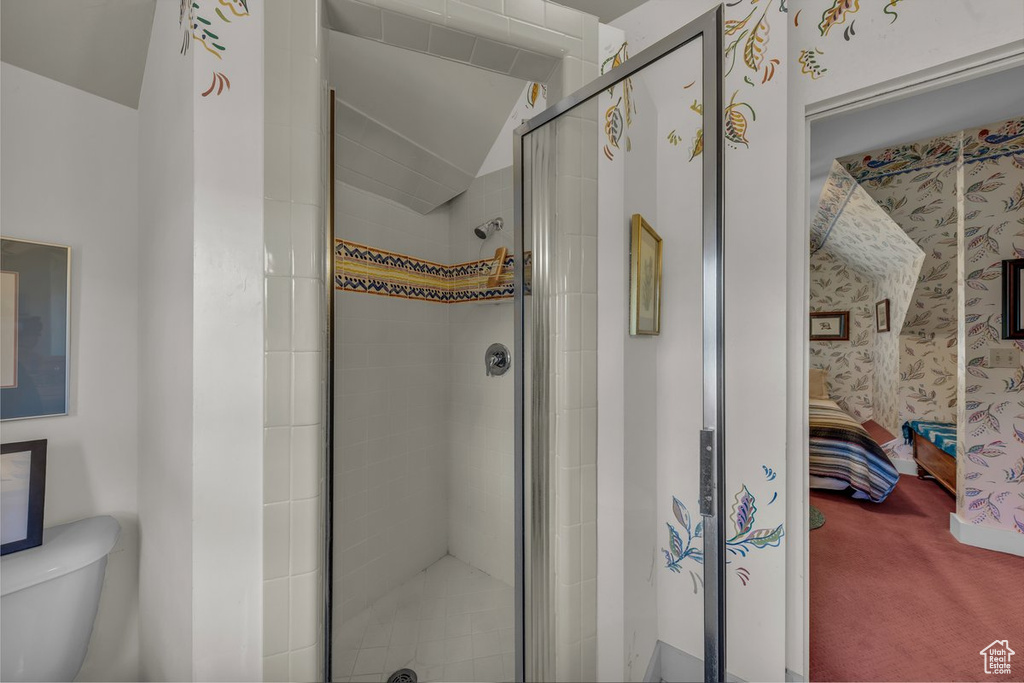 Ensuite bathroom with toilet, a shower stall, and lofted ceiling