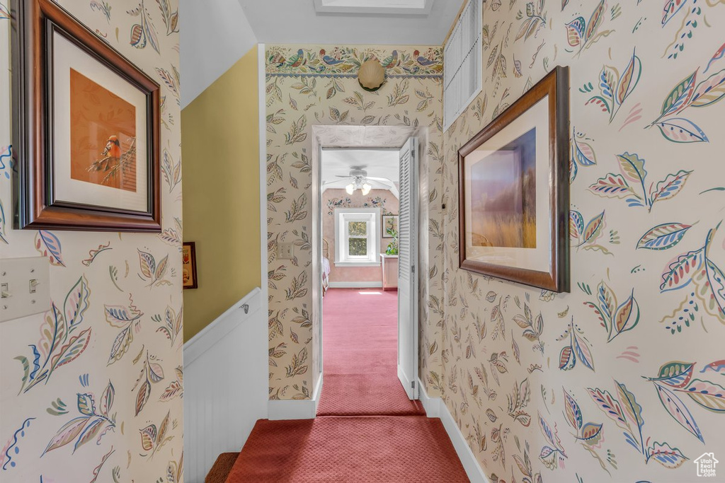 Corridor featuring wallpapered walls and carpet