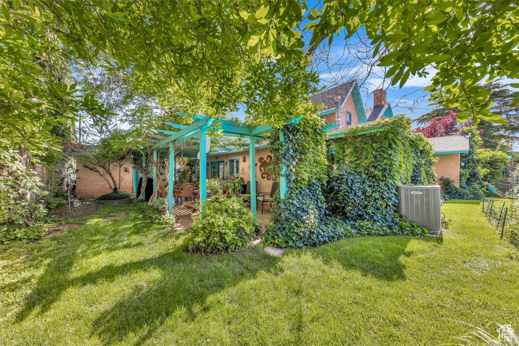 View of yard featuring cooling unit, a pergola, and a patio area
