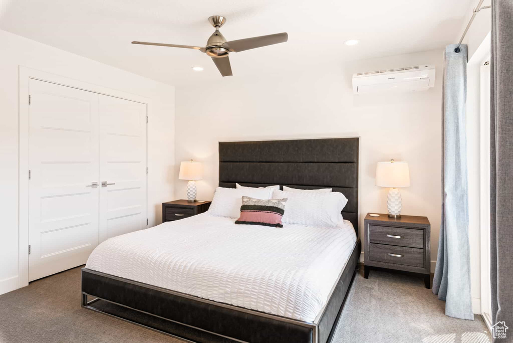 Bedroom featuring a wall unit AC, light carpet, a closet, recessed lighting, and a ceiling fan