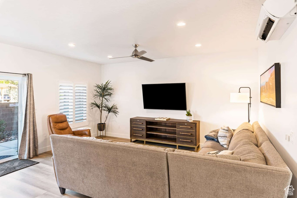 Living room featuring a ceiling fan, light wood finished floors, recessed lighting, and baseboards