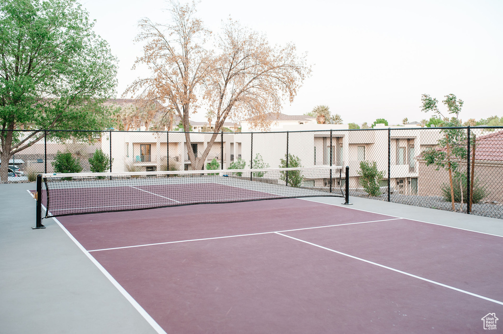 View of tennis court with community basketball court and fence