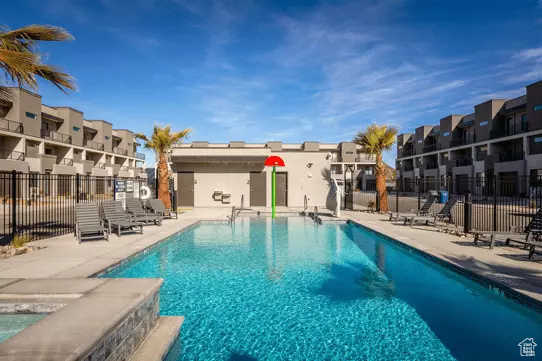 Community pool featuring fence, a patio area, and a residential view