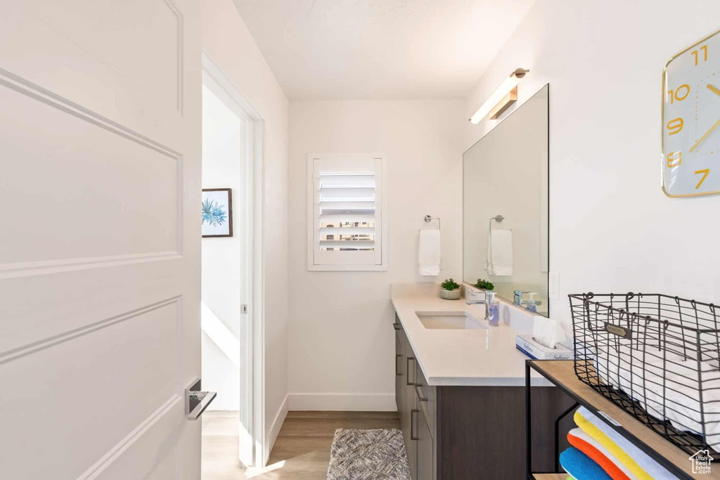 Bathroom with baseboards, wood finished floors, and vanity