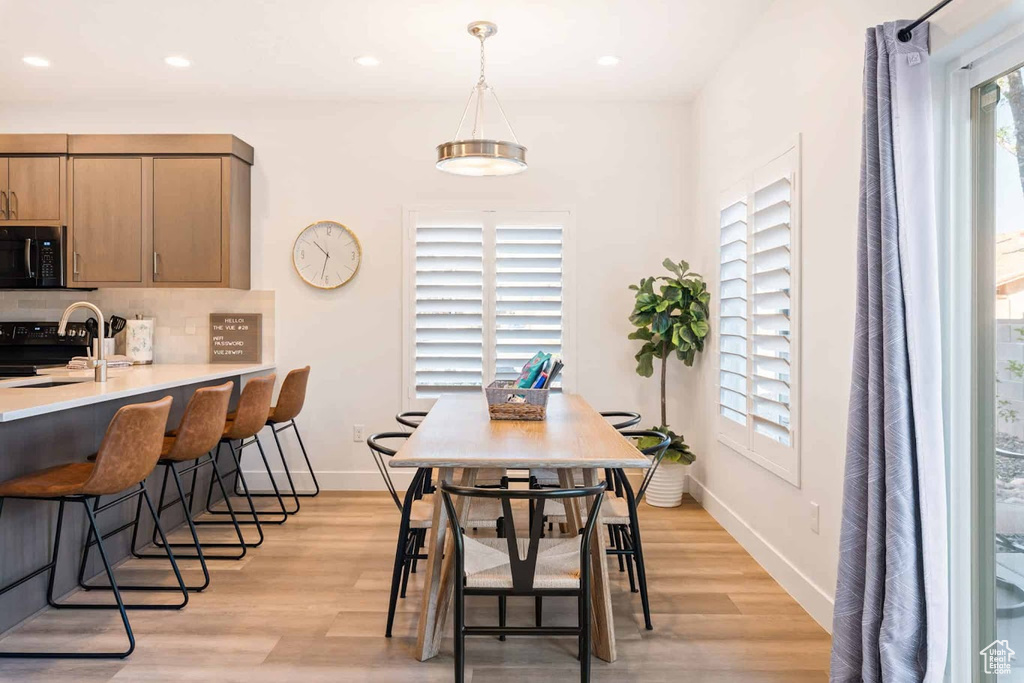 Dining area featuring light wood finished floors, plenty of natural light, recessed lighting, and baseboards