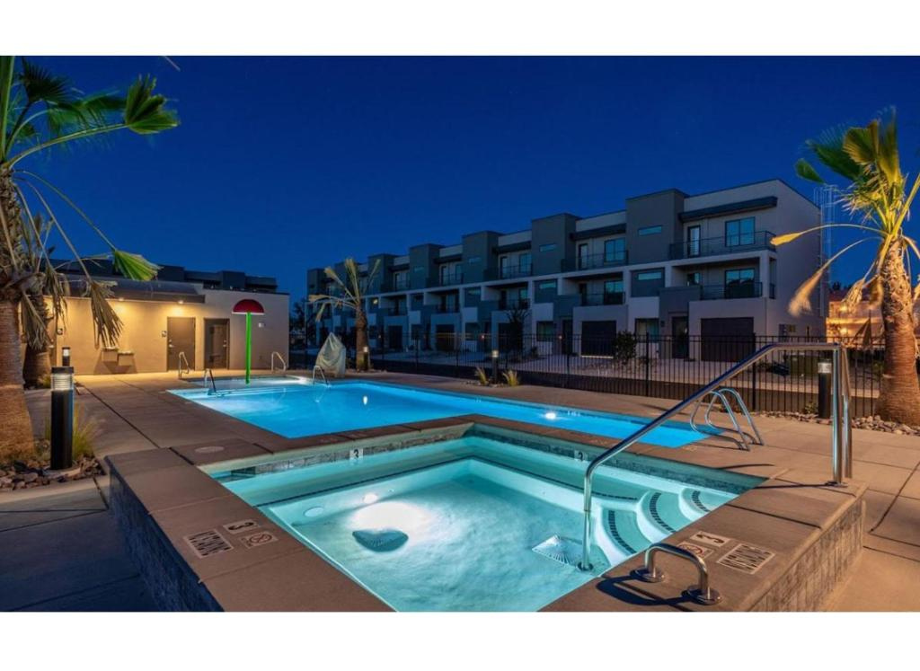 View of swimming pool featuring a community hot tub and fence