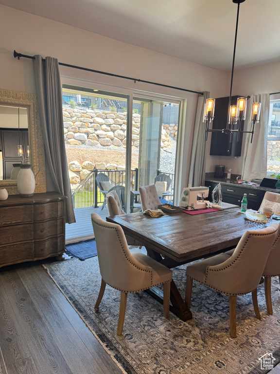 Dining space with wood finished floors and a chandelier