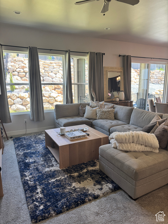 Carpeted living area with a ceiling fan, baseboards, and recessed lighting