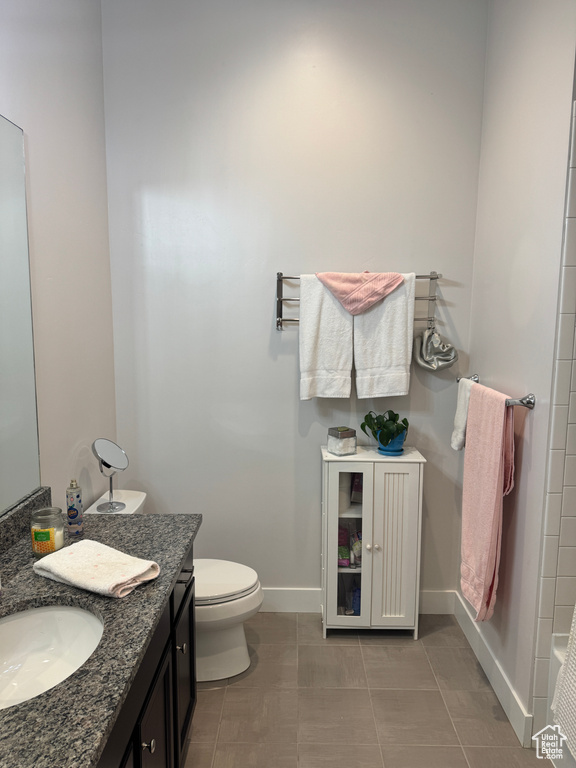 Full bath featuring baseboards, toilet, and vanity