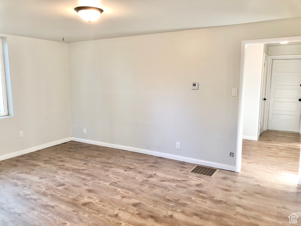 Empty room with visible vents, baseboards, and wood finished floors