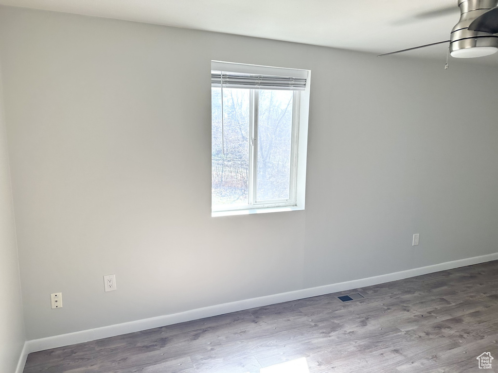 Spare room featuring wood finished floors, baseboards, and visible vents