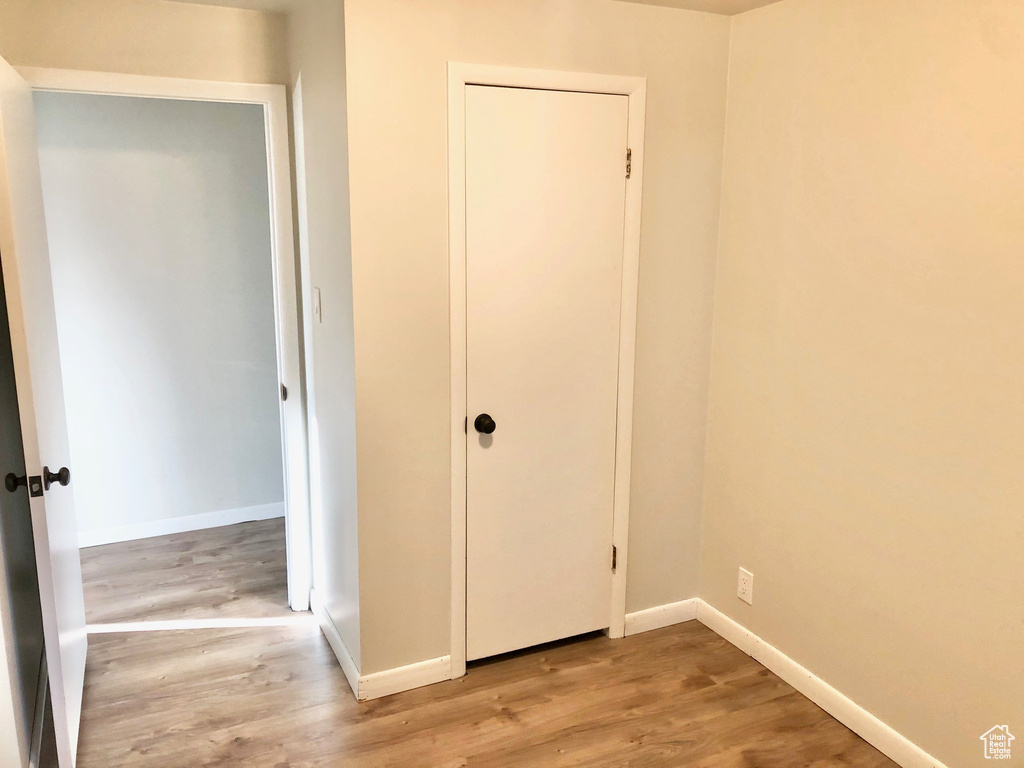 Unfurnished bedroom with a closet, baseboards, and wood finished floors