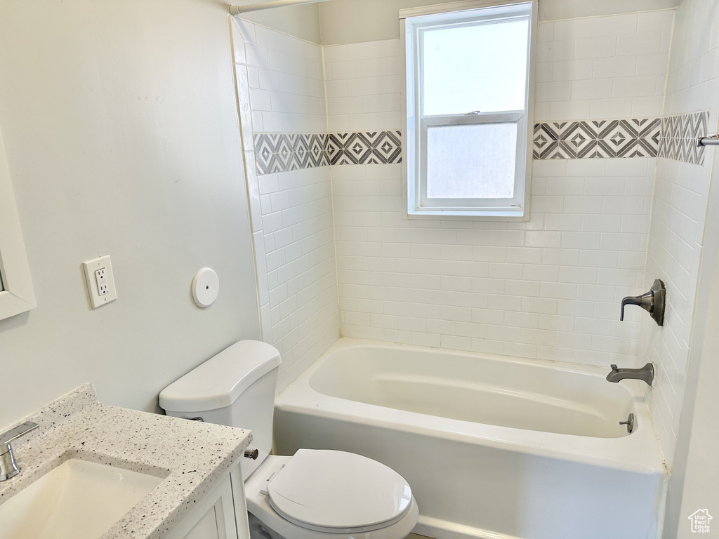 Full bathroom with toilet, vanity, and shower / washtub combination