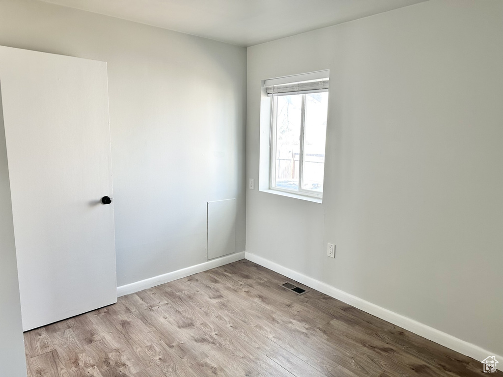 Unfurnished room with visible vents, baseboards, and wood finished floors