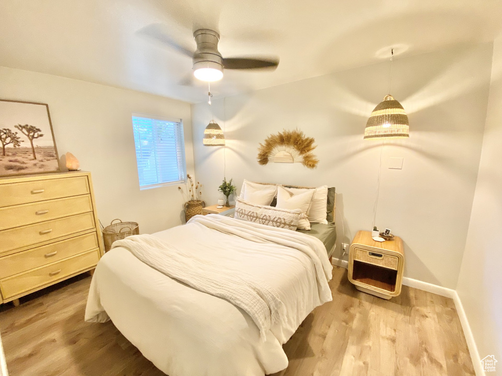 Bedroom with wood finished floors, ceiling fan, and baseboards