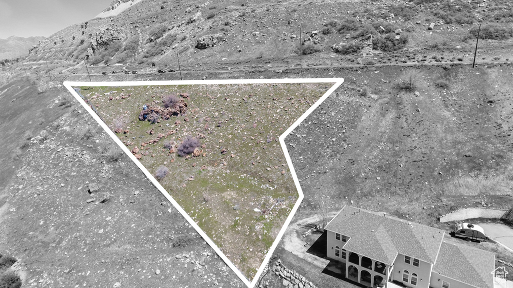 Aerial view of property and surrounding area featuring mountains and property boundaries highlighted