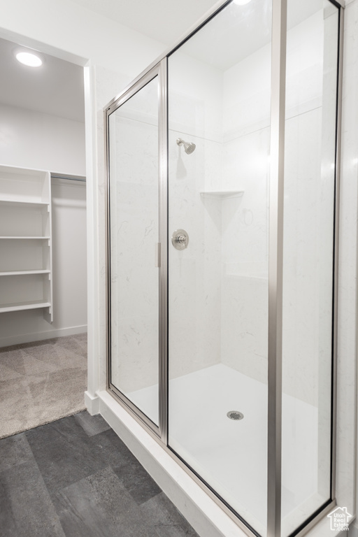 Full bathroom with a stall shower, a walk in closet, and recessed lighting
