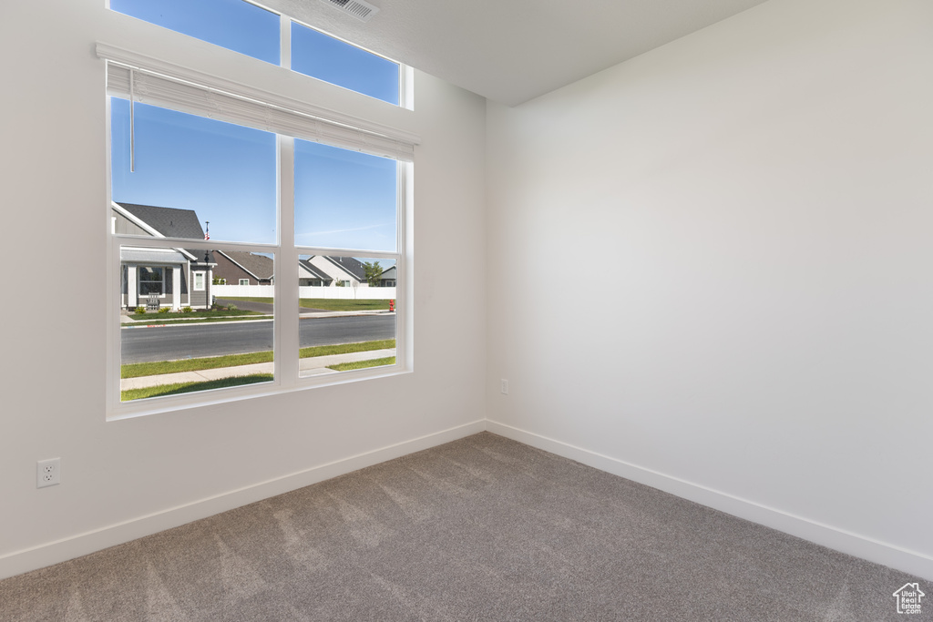 Spare room featuring carpet and baseboards