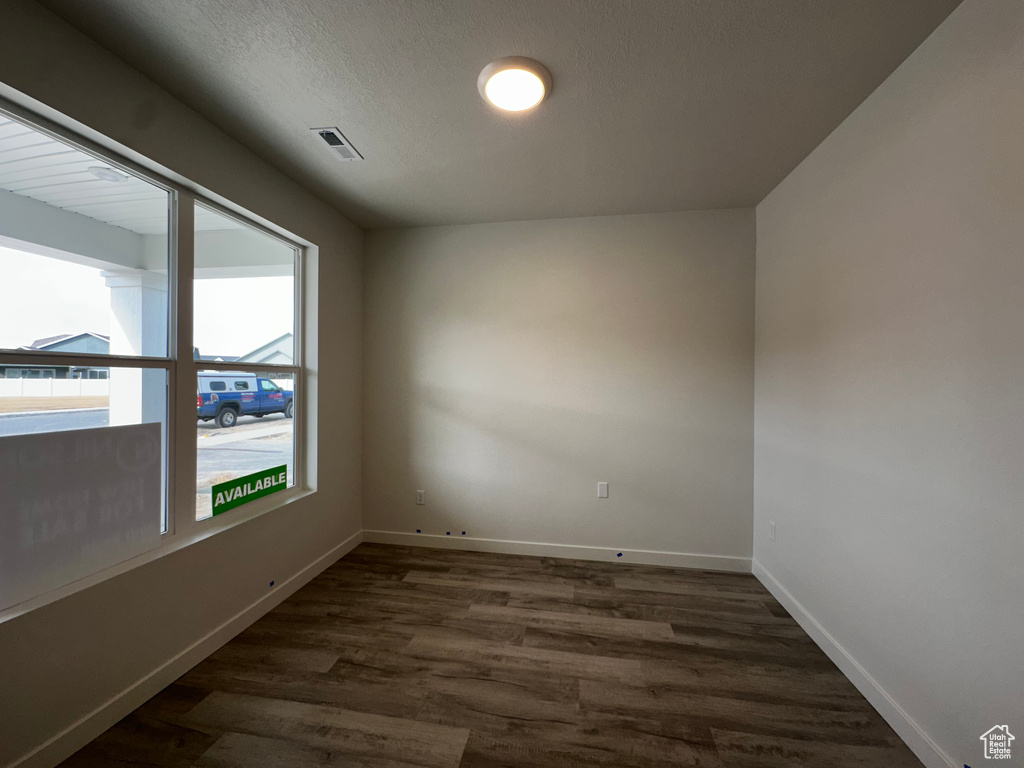 Unfurnished room with dark wood-style floors and baseboards