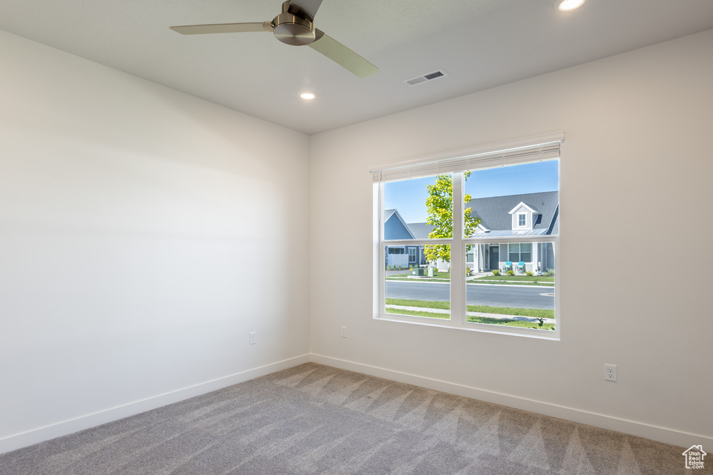 Carpeted spare room featuring baseboards, recessed lighting, and ceiling fan