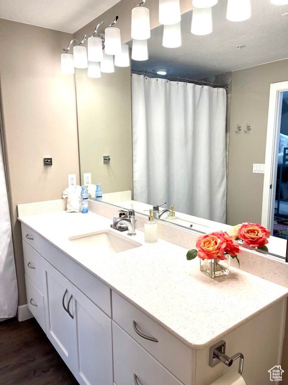 Full bath with vanity and wood finished floors