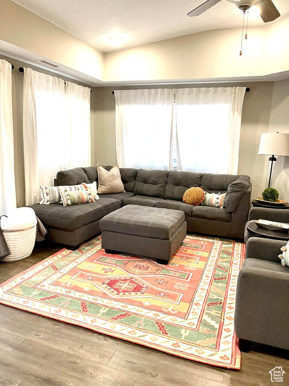 Living area with lofted ceiling, ceiling fan, and wood finished floors