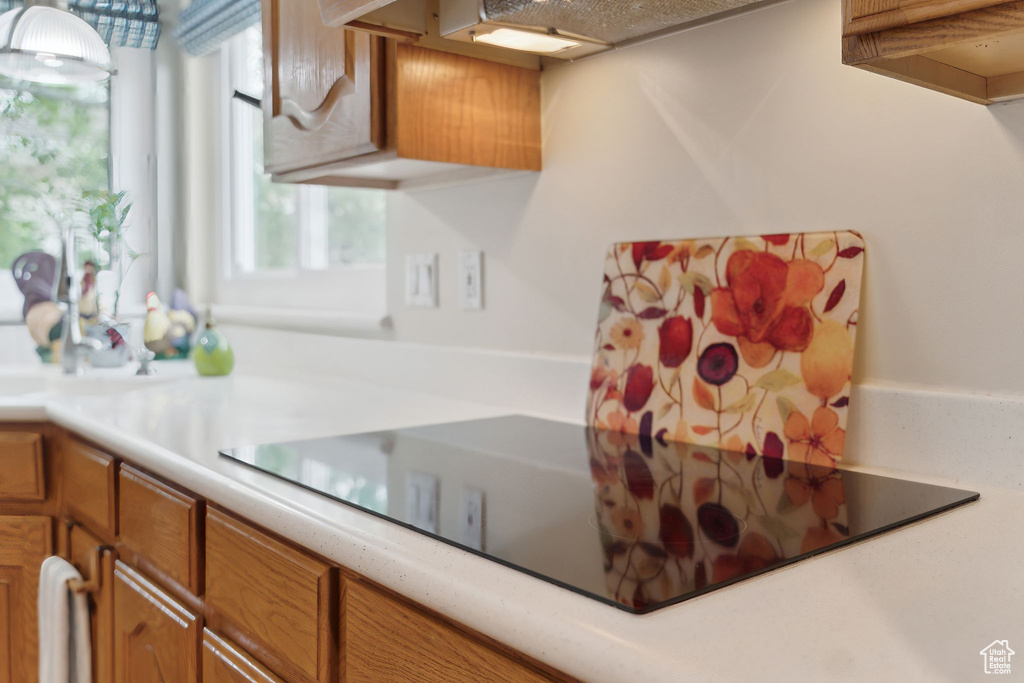 Kitchen featuring light countertops, brown cabinetry, and black electric cooktop