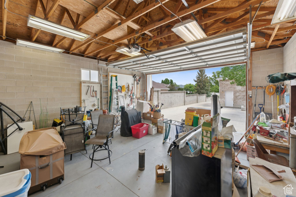 Garage featuring a garage door opener and concrete block wall