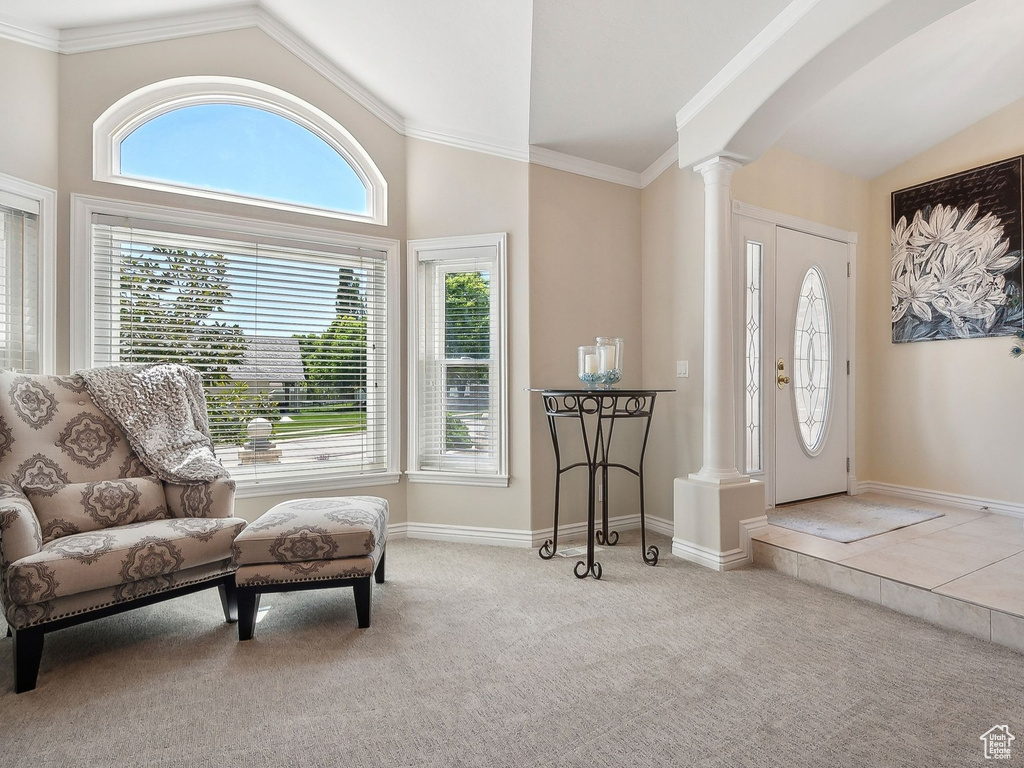 Entrance foyer featuring vaulted ceiling, ornate columns, arched walkways, carpet flooring, and baseboards