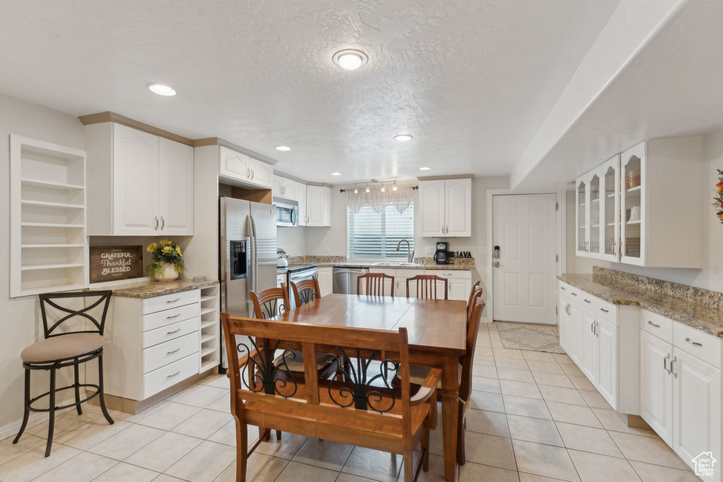 Dining area featuring a textured ceiling, light tile patterned flooring, and recessed lighting