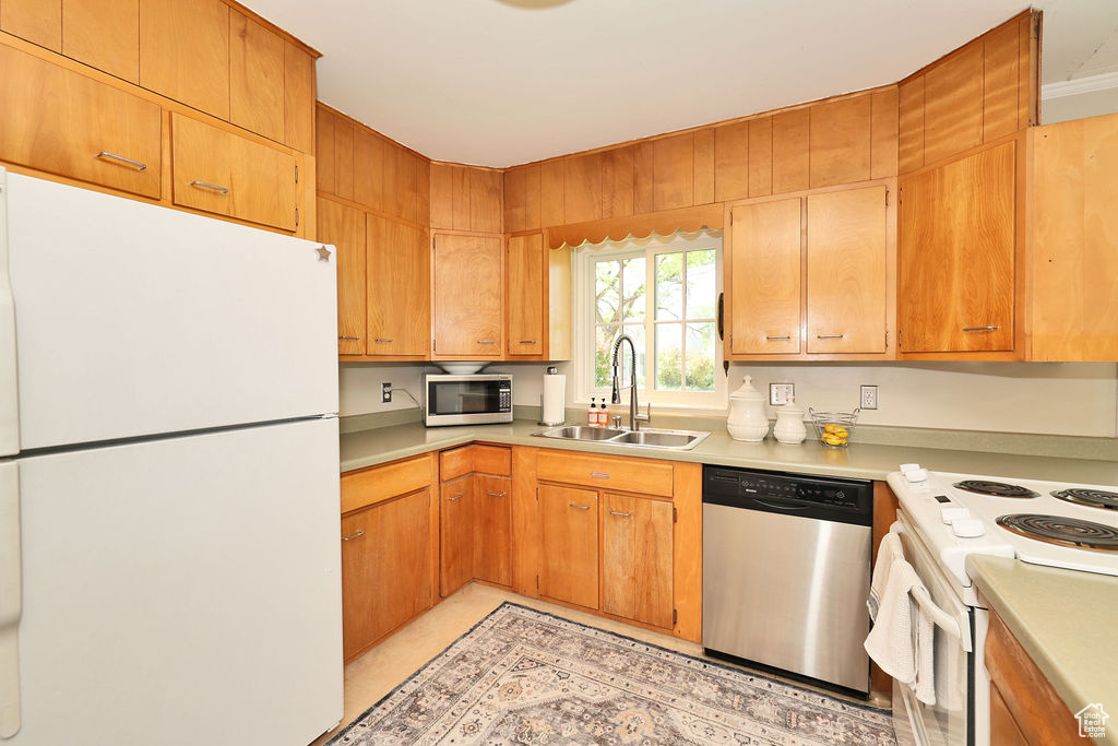 Kitchen featuring appliances with stainless steel finishes, a sink, and light countertops