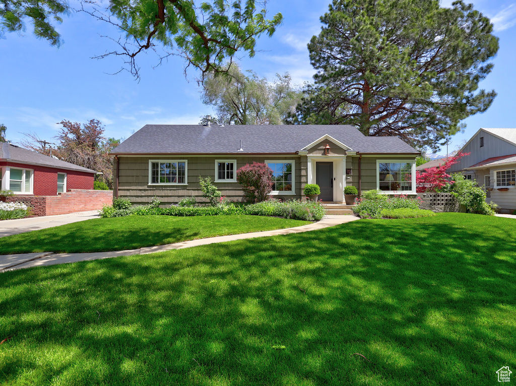 Ranch-style home featuring a front lawn