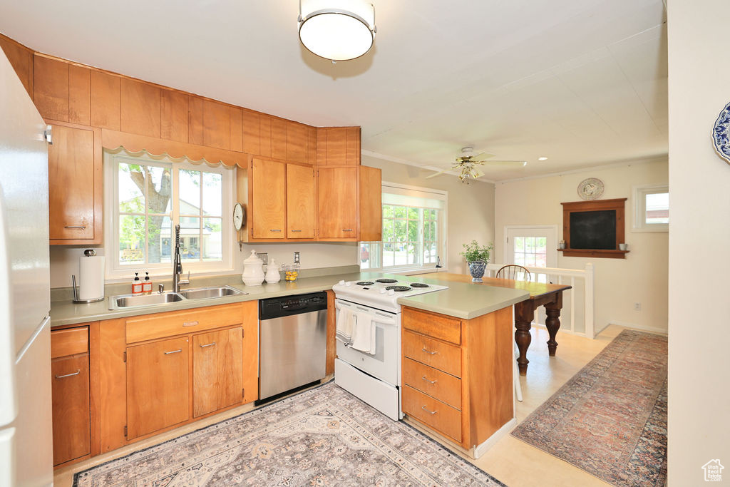 Kitchen featuring dishwasher, electric range, a sink, a peninsula, and fridge