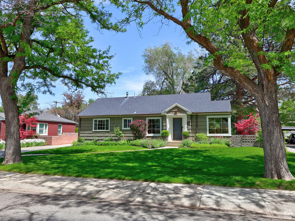 Ranch-style home featuring a front lawn
