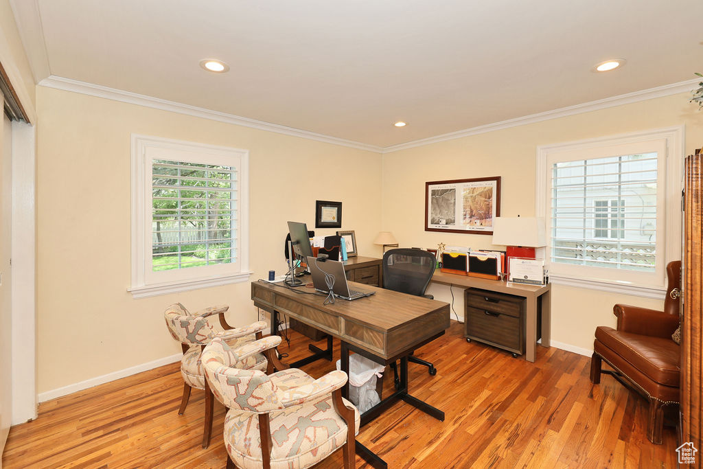 Office space with light wood finished floors, ornamental molding, baseboards, and recessed lighting