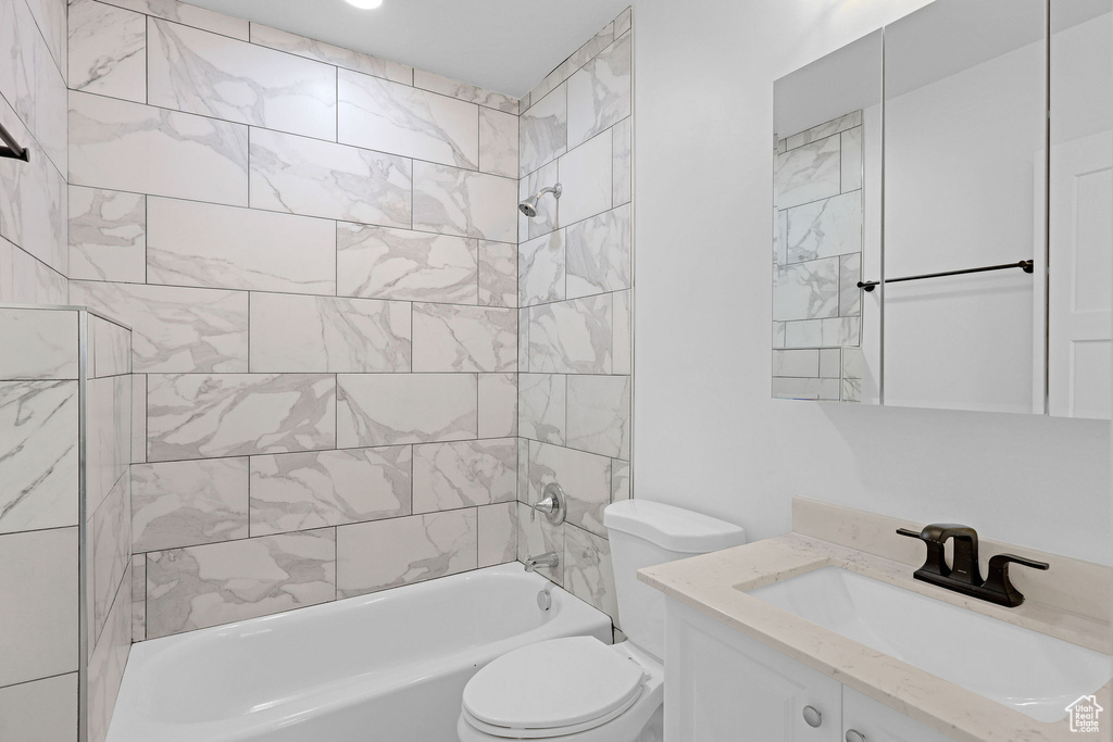 Bathroom featuring toilet, shower / washtub combination, and vanity