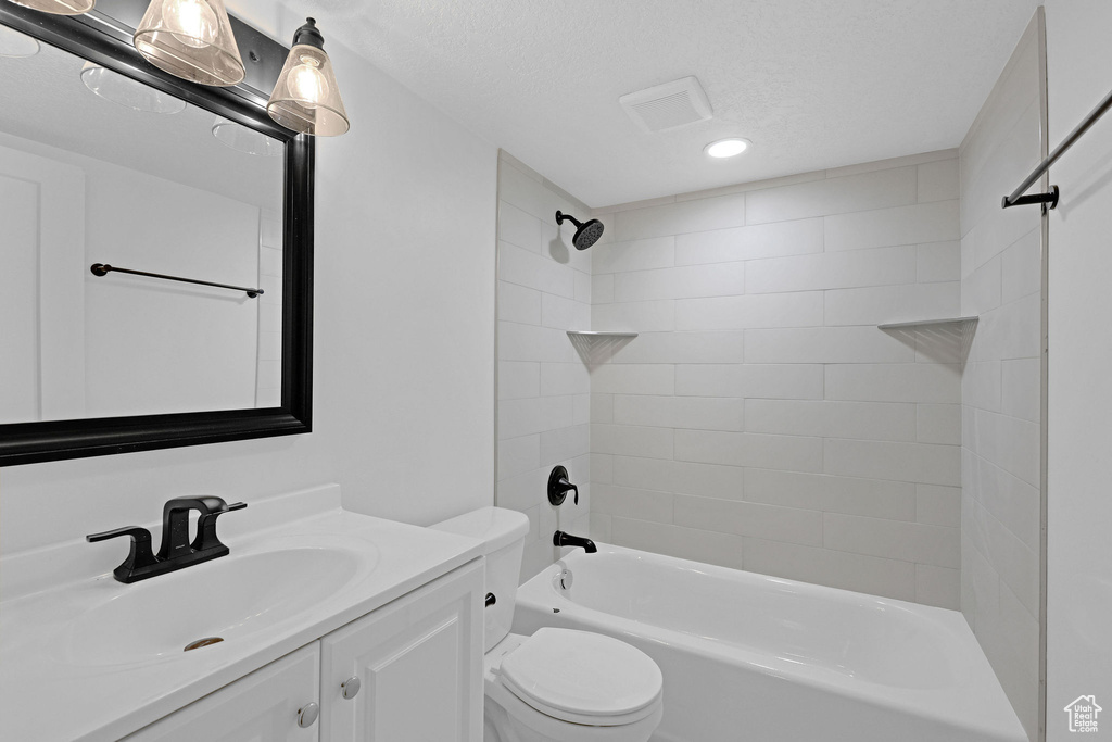 Bathroom with toilet, recessed lighting, vanity, bathing tub / shower combination, and a textured ceiling