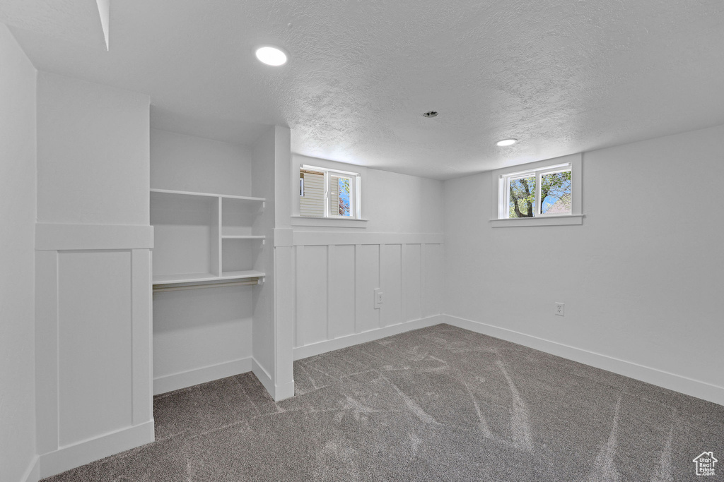 Below grade area with carpet, a textured ceiling, baseboards, and recessed lighting