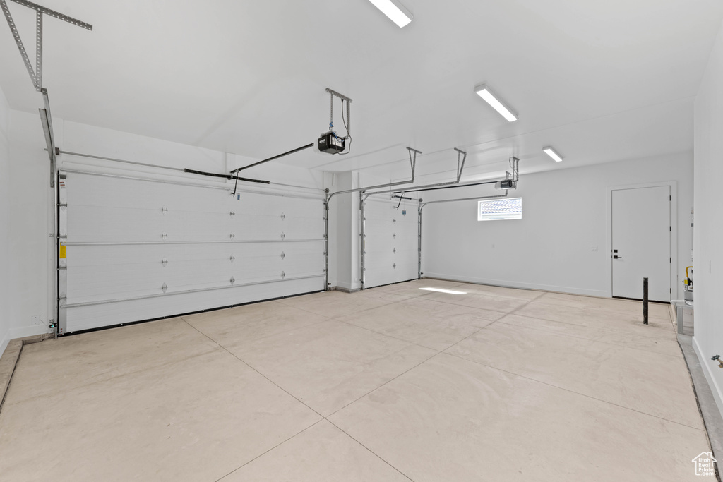 Garage with a garage door opener and baseboards