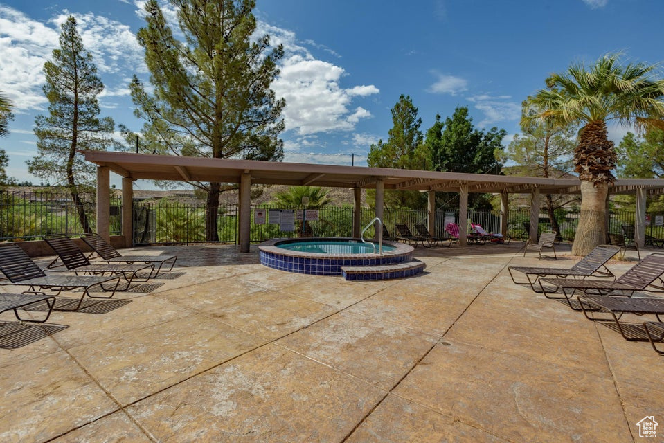 View of patio featuring a hot tub and fence