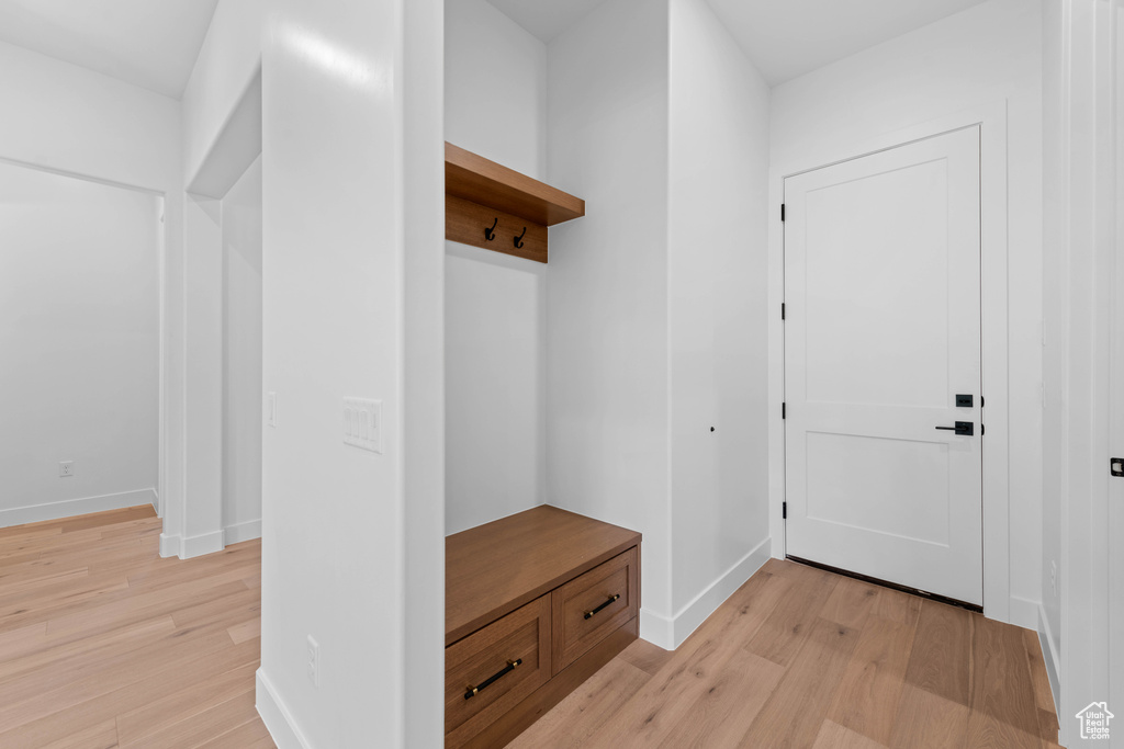 Mudroom with light wood-style floors and baseboards