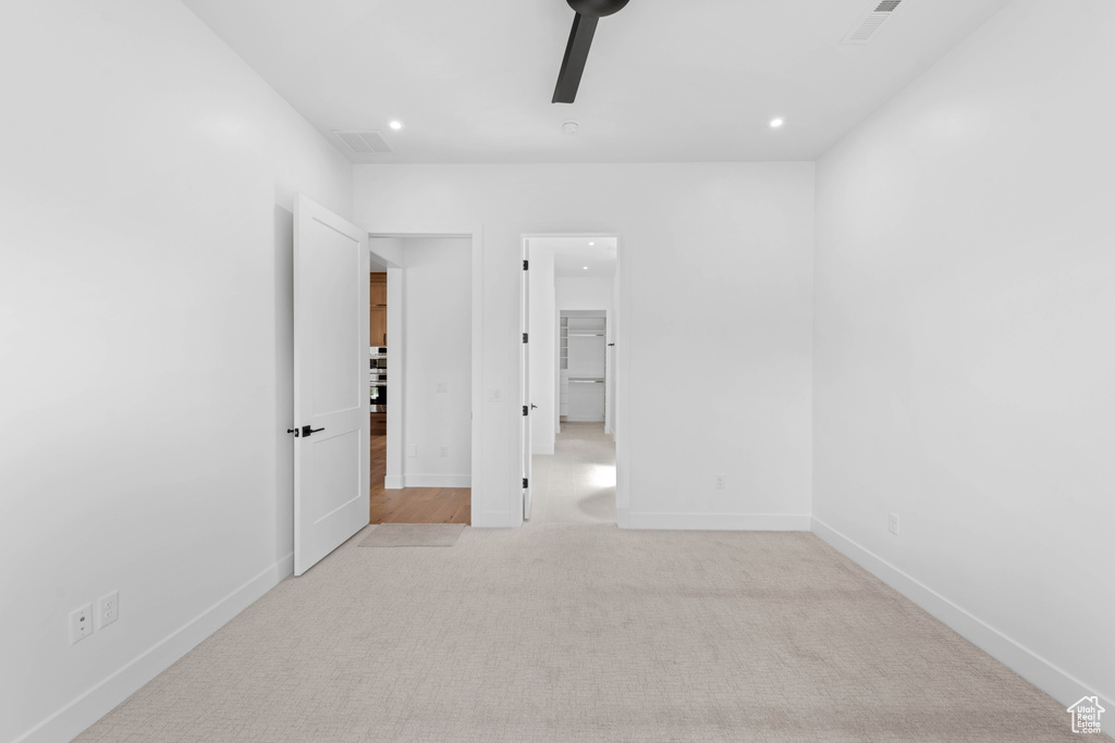 Unfurnished bedroom featuring light colored carpet, recessed lighting, baseboards, and ceiling fan